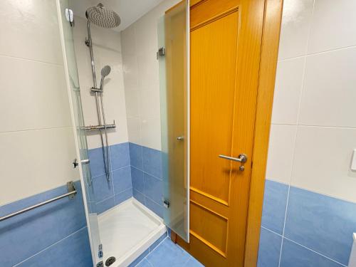 a bathroom with a shower and a wooden door at ACV- Terrazas II-2ª linea planta 9 este in El Borseral