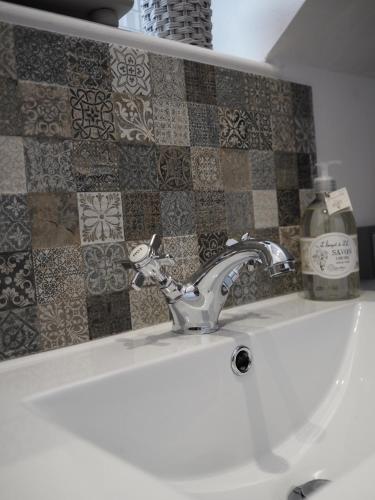 a bathroom sink with a faucet and a bottle of soap at The Old Surgery in Thirsk