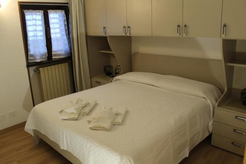 a bedroom with a bed with white towels on it at Appartamento Il Fraitevino Sestriere at Champlas du Col in Sestriere