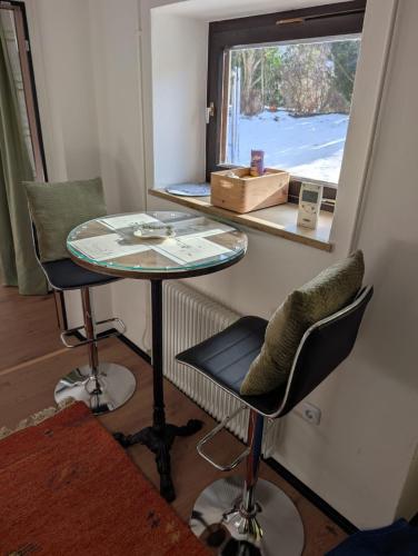 a table and two chairs in a room with a window at Haus Edlinger - Gartenblick in Hinterstoder