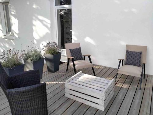 three chairs and a table on a deck at Demeure avec piscine in Saint-Viaud