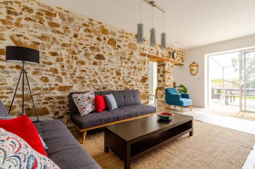 a living room with a couch and a table at Demeure avec piscine in Saint-Viaud