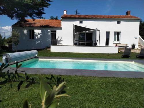 a villa with a swimming pool in front of a house at Demeure avec piscine in Saint-Viaud