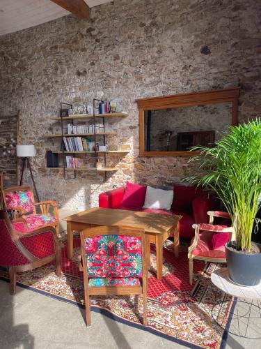 a living room with a couch and a table and chairs at Demeure avec piscine in Saint-Viaud