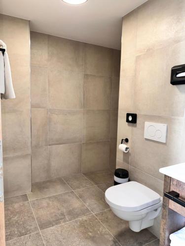a bathroom with a toilet and a shower at Hotel Lainbach in Wängle in Reutte