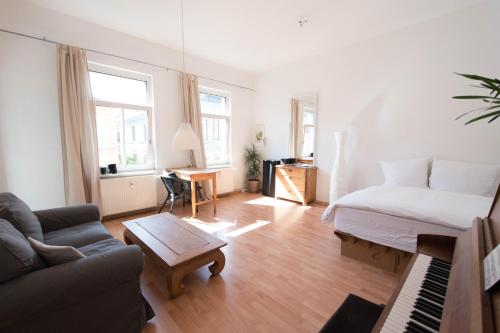 a living room with a couch and a bed and a piano at Wohnung Peter in Weimar