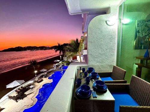 a table with blue dishes on it next to the beach at Espectacular Apto a pie de Playa con vista al mar in Manzanillo