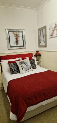 a bedroom with a red and white bed with pillows at The Dudley Hotel in Blackpool