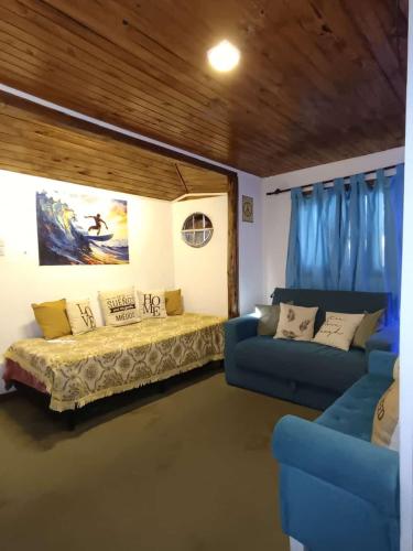 a living room with a bed and a couch at Mar del Plata- Playa Chapadmalal- Finca Viento Norte UNA CABAÑA HASTA 5 HUESPEDES Y UN DORMI CON BAÑO PRIVADO ATRAS HASTA 2 HUESPEDES in Chapadmalal