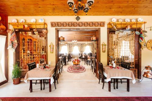 a restaurant with tables and chairs in a room at Almond Holiday Village in Kérynia