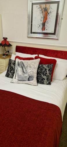 a bedroom with a red and white bed with pillows at The Dudley Hotel in Blackpool