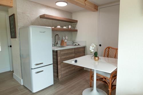 a kitchen with a white refrigerator and a table at Seahorse Beach Bungalows in Fort Pierce
