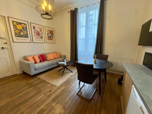 un salon avec une table et un canapé dans l'établissement Les Lys d'Or Appartement avec Jacuzzi, à Saumur