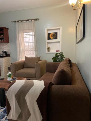 a living room with two couches and a table at A-grade living-WiFi & parking in Kampala