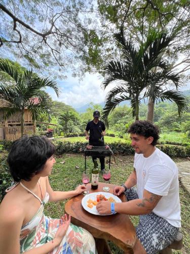 a man and a woman sitting at a table with a plate of food at Tayrona Cachaco River Ecohostal in El Zaino