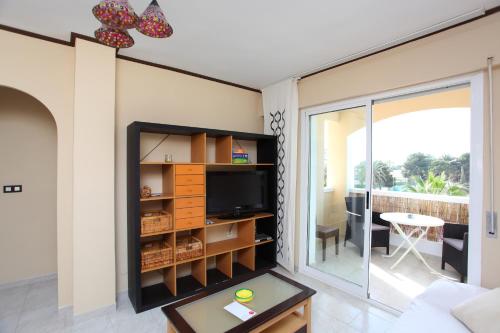 a living room with a tv and a balcony at Bolnuevo Apartment in Bolnuevo