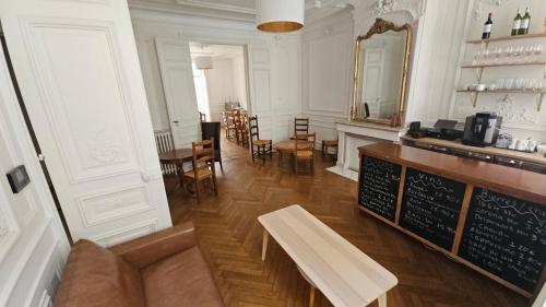 un restaurant avec un comptoir et un banc dans une salle dans l'établissement Bed in 6-beds Women Dormitory Le Jardin Cafe, à Bordeaux