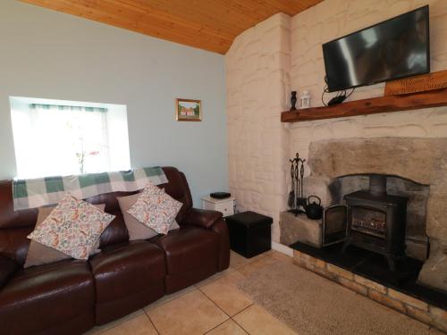 a living room with a couch and a fireplace at Dan White's Cottage in Newry