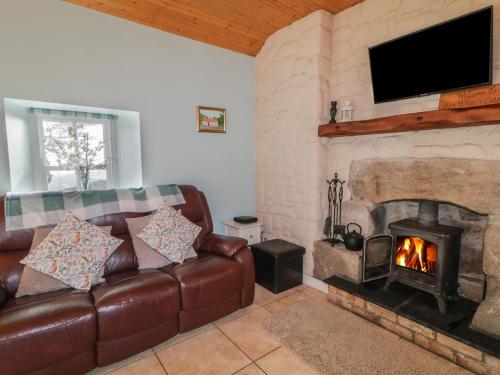 a living room with a couch and a fireplace at Dan White's Cottage in Newry