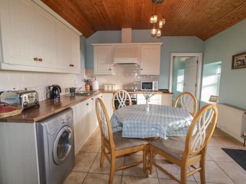 a kitchen with a table and chairs in a kitchen at Dan White's Cottage in Newry