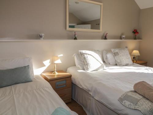 a bedroom with two beds and a mirror on the wall at Dan White's Cottage in Newry