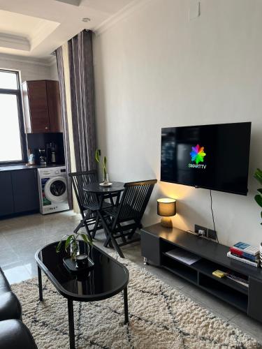 a living room with a flat screen tv on a wall at CosyNook in Kigali