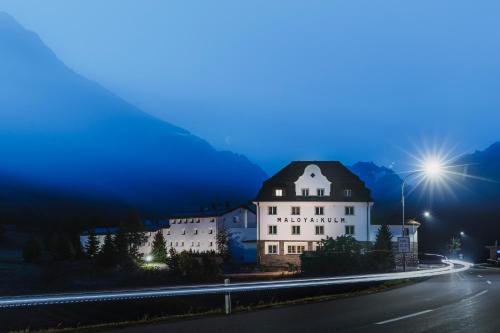a building on the side of a road at night at Hotel Maloja Kulm in Maloja