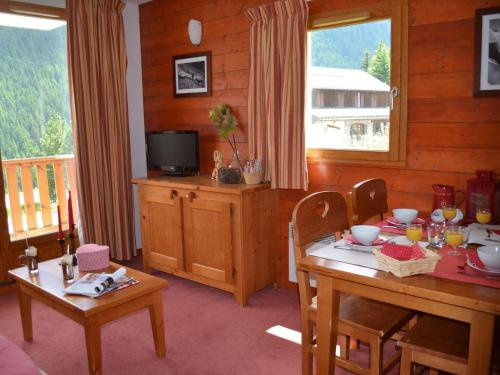 une salle à manger avec une table et une télévision dans l'établissement Pet-Friendly Ski Retreat, à Valfréjus