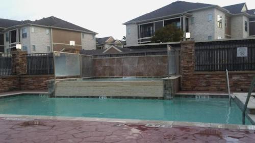 a swimming pool in front of a house at Fairfield Inn and Suites by Marriott North Spring in Spring