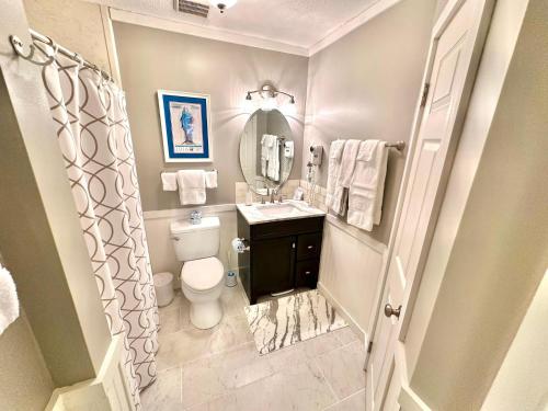 a bathroom with a toilet and a sink and a mirror at 750 Sandpiper in Destin