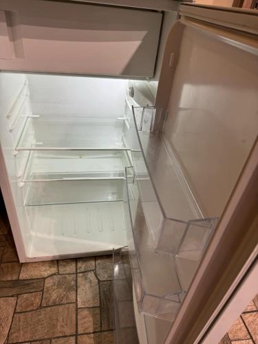 an empty refrigerator with its door open in a kitchen at Leśna Oaza in Rydzów