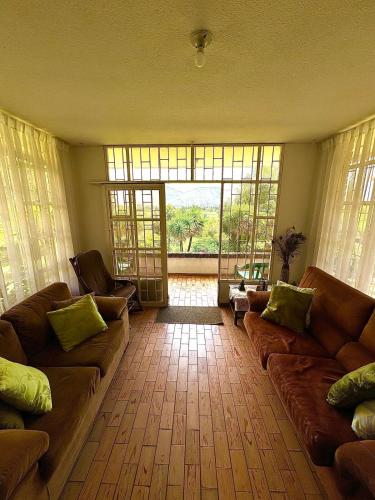 a living room with couches and a large window at Huitaca Maravillosa Casa Campestre en Tibasosa in Tibasosa