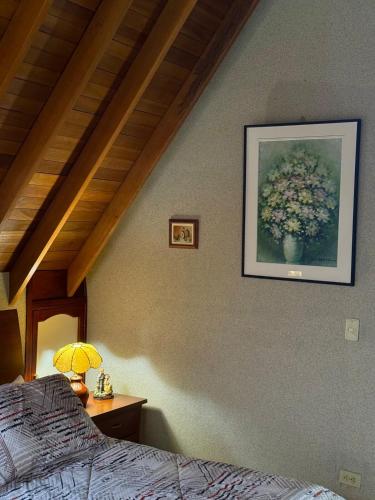 a bedroom with a picture of a vase of flowers on the wall at Huitaca Maravillosa Casa Campestre en Tibasosa in Tibasosa