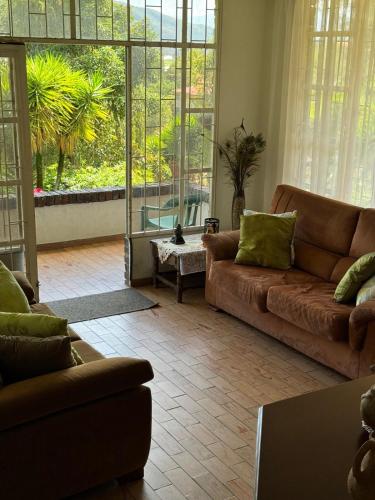 a living room with two couches and a large window at Huitaca Maravillosa Casa Campestre en Tibasosa in Tibasosa