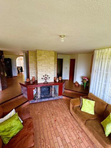 a living room with couches and a fireplace at Huitaca Maravillosa Casa Campestre en Tibasosa in Tibasosa