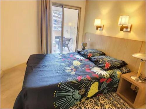 - une chambre avec un lit et une couverture colorée dans l'établissement Bel appartement avec grande terrasse à 50m de la plage, à Cannes