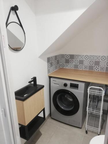 - une buanderie avec un lave-linge et un évier dans l'établissement Charmante maison de village, à Bouillargues