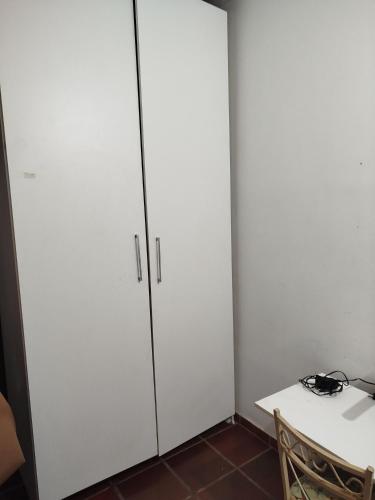 two white cabinets in a room with a table at Lar da Elis in Riacho Fundo