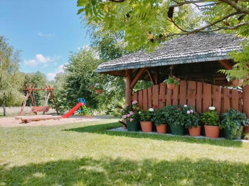 a garden with a gazebo with pots of plants at Agroturystyka nad Wigrami pokoje u Kasi i Tomka in Cimochowizna