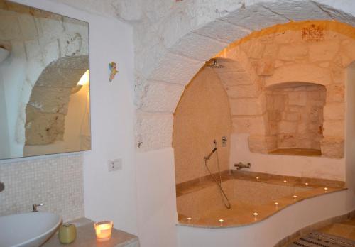 e bagno con vasca in un muro di pietra. di Trullo Amico a Cisternino