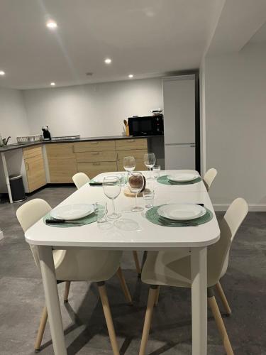 a white table with chairs and wine glasses on it at Les chambre de Marie Appartement Rez de chaussé in Didenheim
