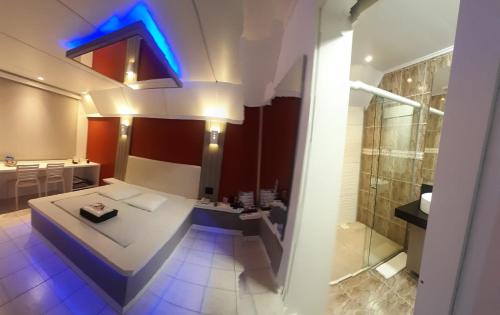 a bathroom with a shower and a toilet and a sink at Astral Motel in Caxias do Sul