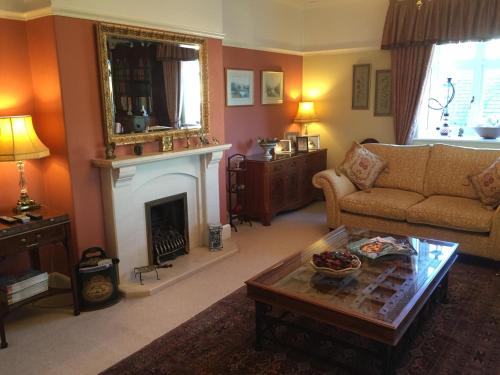 a living room with a couch and a fireplace at Stoneborough House B&B in Budleigh Salterton