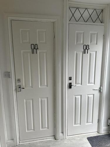 two white doors with crosses on them in a room at Inspire Home Stylish Stay E in Cardiff