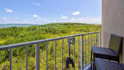 a balcony with chairs and a view of the ocean at Heavenly Hideaway Ocean Pointe 3306 in Tavernier