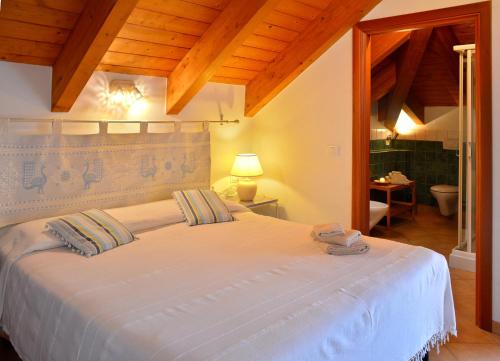 a bedroom with a large white bed in a room at Pessighette Dimora Di Campagna in Bosa
