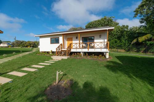 a small white house with a porch in a yard at Paradise Reef Villas in French Harbour