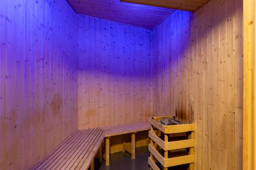 a wooden room with a wooden bench and purple lights at Apartaments Sant Moritz in Arinsal