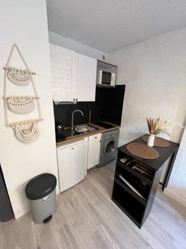 une petite cuisine avec un évier et une cuisinière dans l'établissement Cocon Azur Studio Cavalaire, à Cavalaire-sur-Mer