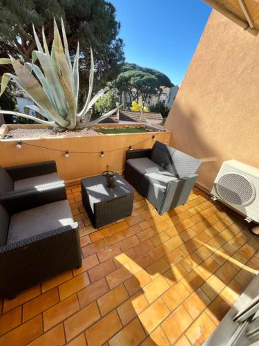 d'une terrasse avec deux chaises et une table. dans l'établissement Cocon Azur Studio Cavalaire, à Cavalaire-sur-Mer